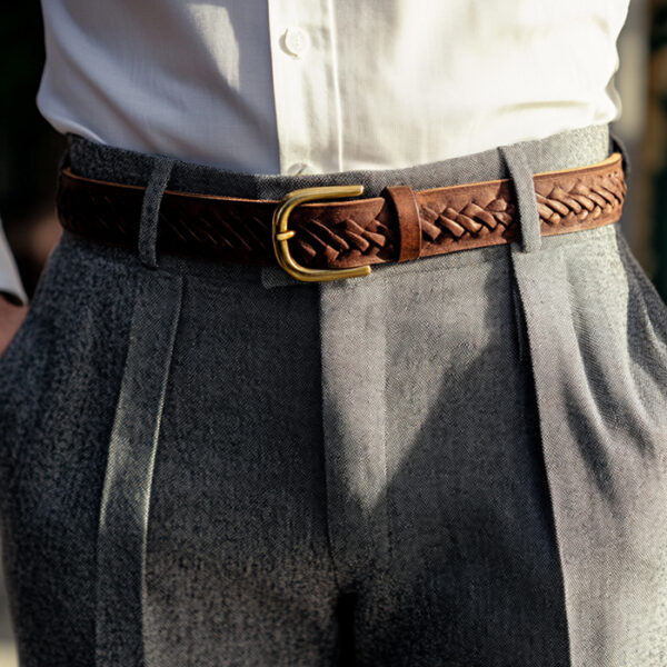 wide-leg, high-waisted, pleated, gray wool trousers with a brown braided leather belt with a brass buckle